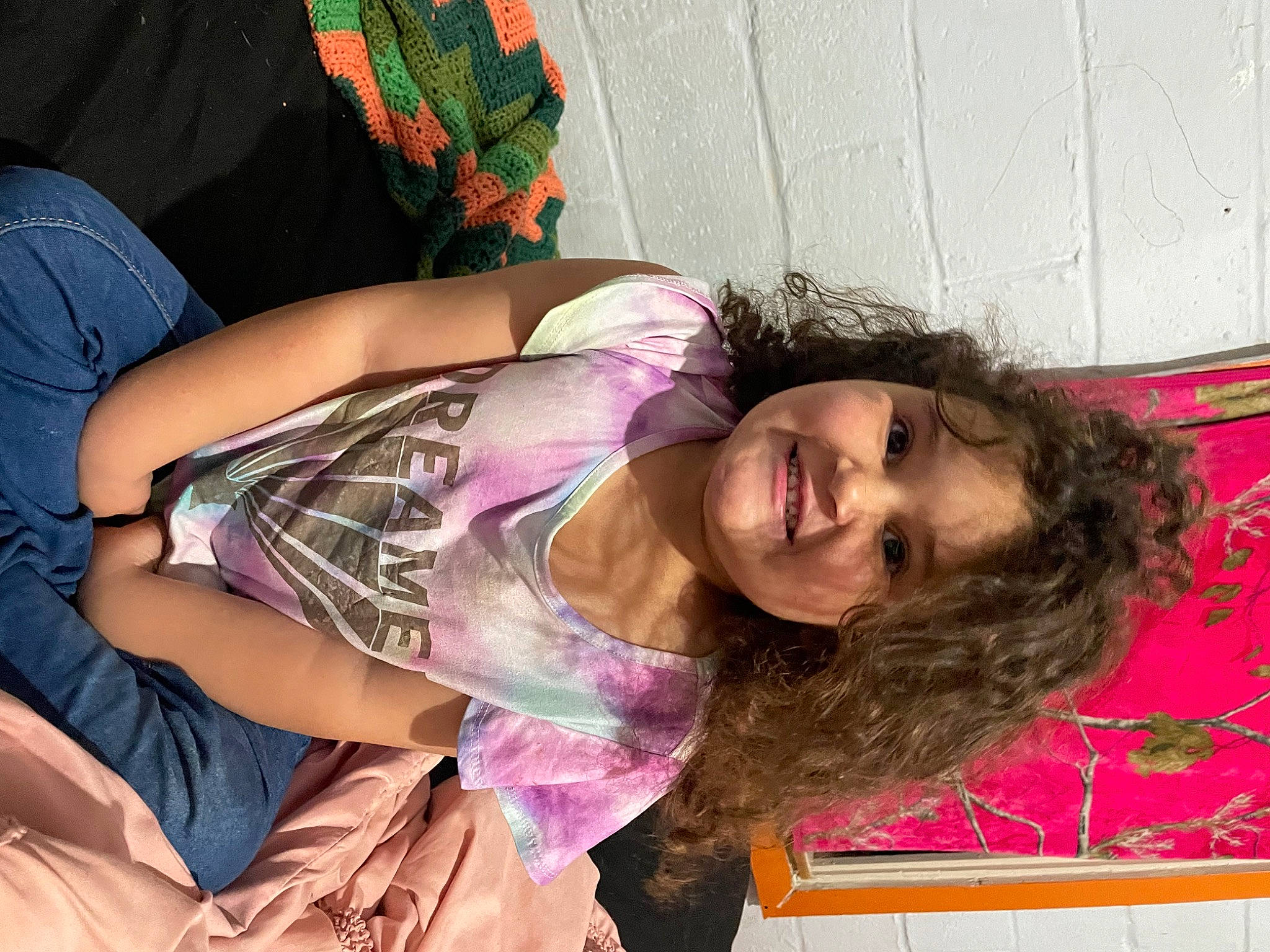 Jamie is registered to the contest to win money with this photo: abdomen, child, comfort, elbow, fun, happy, human_leg, joint, joy, leisure, magenta, mouth, pattern, person, pink, purple, shoulder, sitting, smile, thigh