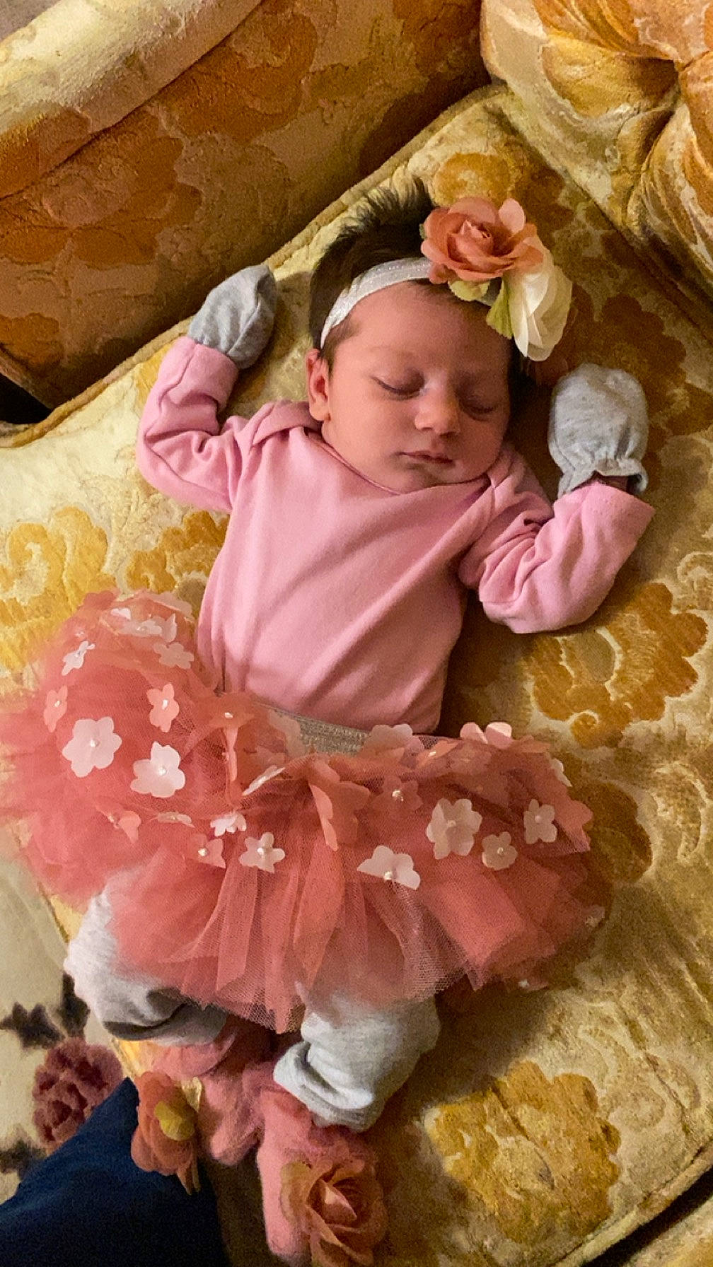 Athena is registered to the contest to win money with this photo: baby, baby_products, baby_sleeping, baby_toddler_clothing, cheek, child, comfort, dress, face, fashion_accessory, hair_accessory, linens, magenta, peach, person, petal, pink, ruffle, sitting, skin