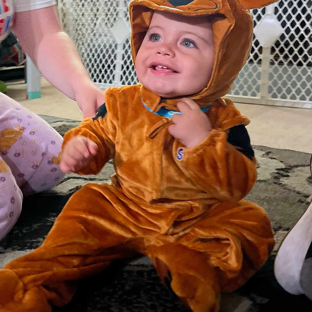 August Levi joined the competition — help win amazing prizes! child, toddler, reindeer_costume, costume, smiling, happy, portrait, indoor, christmas, christmas_tree, holiday, living_room, carpet, playpen, brick_wall, toy_car, brown, sitting, festive, family
