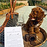 Koby joined the competition — help win amazing prizes! dog, puppy, curly_hair, brown_fur, bandana, sitting, greenhouse, winery, wine, wine_glass, wine_menu, barrel, handbag, camera, garden, plants, outdoor, table, portrait, pet