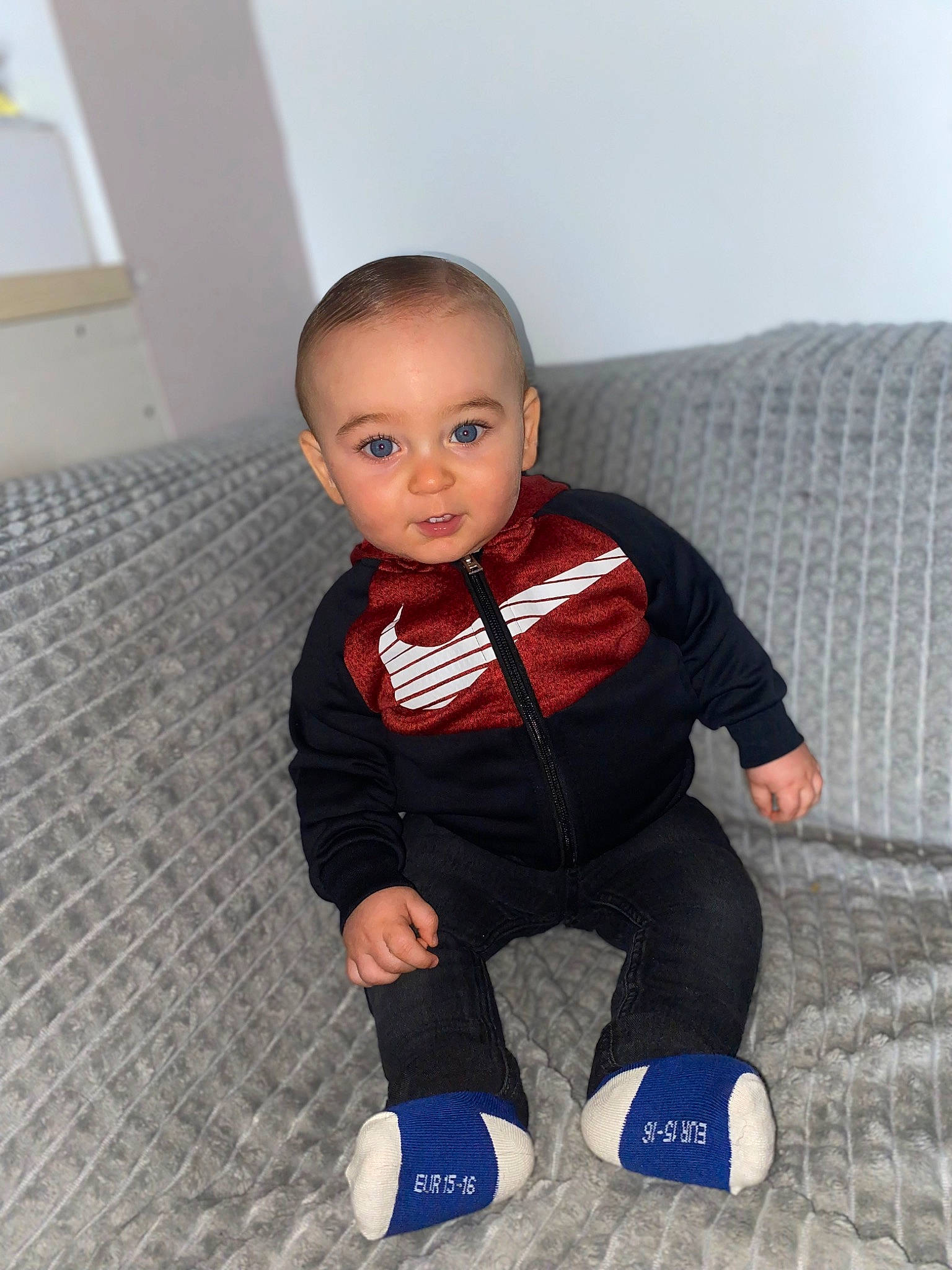 Kaïs participe au concours pour gagner de l'argent avec cette photo : baby, baby_toddler_clothing, ball, cheek, child, comfort, electric_blue, eye, face, flooring, hardwood, head, human_leg, knee, person, sitting, sleeve, sock, t_shirt, toddler