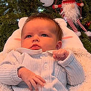 Romy participe au concours pour gagner de l'argent avec cette photo : baby, infant, christmas_tree, ornament, gnome, holiday, lights, cushion, onesie, cozy, cute, festive, decor, soft_texture, portrait, child, indoors, celebration, seasonal, smiling