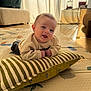 Aloïs participe au concours pour gagner de l'argent avec cette photo : baby, infant, pillow, striped_pillow, floor_mat, indoor, natural_light, smiling, tummy_time, child, cozy, curtains, furniture, home, cute, person, sweater, happy, head, playtime