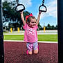 Oakley joined the competition — help win amazing prizes! child, girl, playground, hanging, rings, pink_shirt, red_bow, shorts, smiling, outdoor, daylight, grass, blue_sky, play_equipment, happy, young_child, casual_clothing, recreation, fun, active