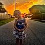child, girl, sunset, street, barefoot, smile, dress, patriotic, outdoor, nature, sky, clouds, fence, grass, residential, happy, portrait, face, evening, casual