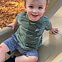 child, toddler, slide, playground, leaves, smile, face, brown_hair, green_shirt, shorts, sock, scraped_knee, hand, fence, outdoor, candid, portrait, daylight, happy, play