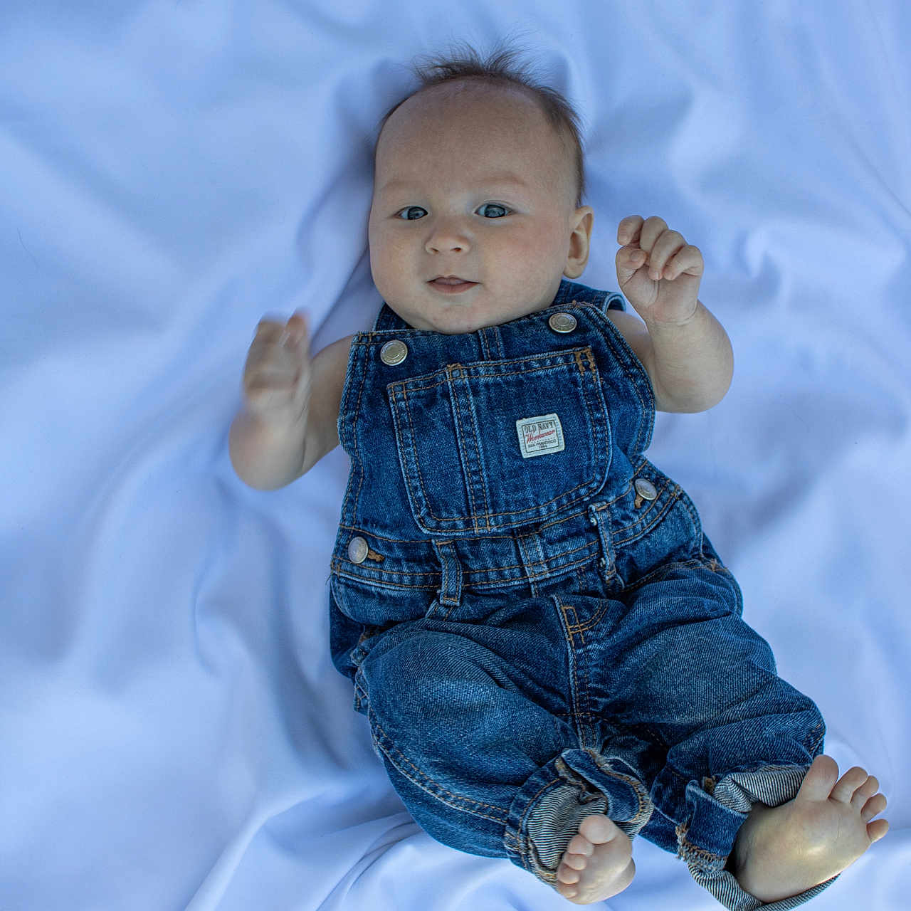 Chimmy joined the competition — help win amazing prizes! baby, denim_overalls, infant, blue_sheet, barefoot, cute, child, portrait, hands, feet, smiling, lying_down, clothing, face, skin, small_hands, small_feet, young_child, casual, indoors