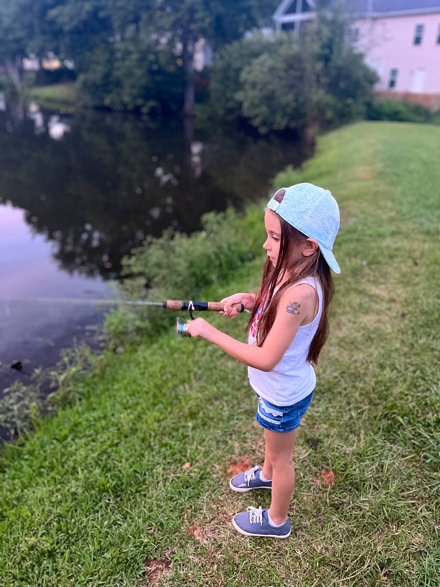 Skylar is registered to the contest to win money with this photo: baseball_cap, cap, electric_blue, grass, grassland, happy, hat, lake, landscape, lawn, leisure, meadow, people_in_nature, person, plant, recreation, shorts, summer, toddler, tree