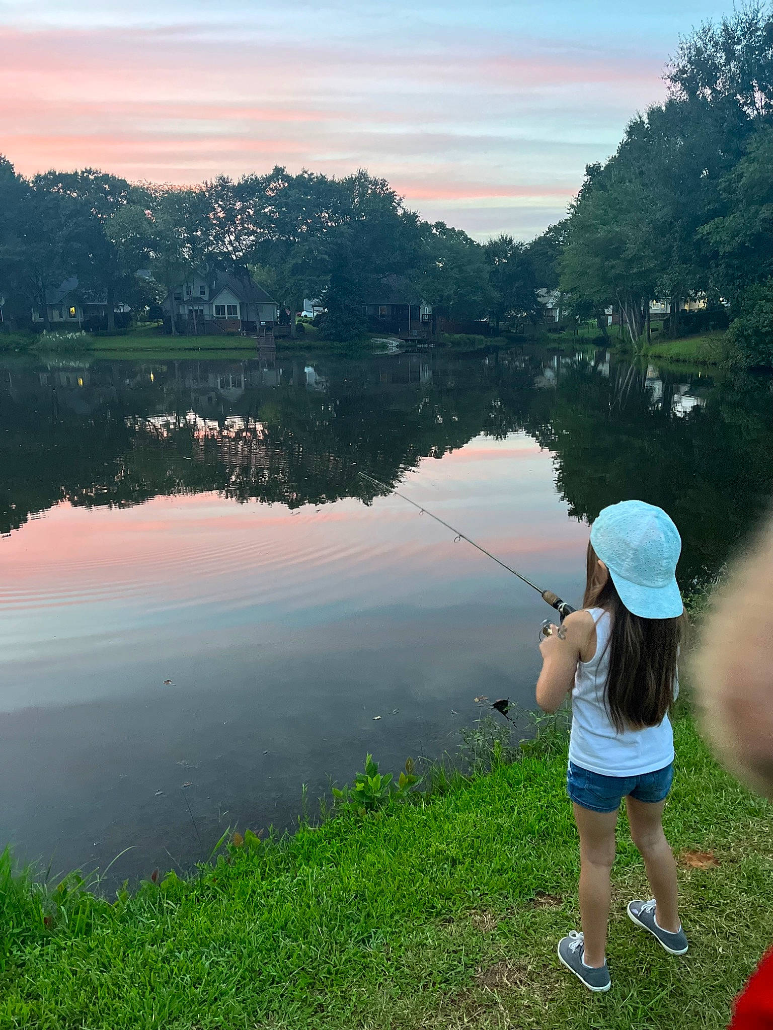 Skylar is registered to the contest to win money with this photo: angling, bank, cloud, grass, grassland, happy, lacustrine_plain, lake, landscape, leisure, natural_landscape, nature, people_in_nature, person, plant, recreation, recreational_fishing, shorts, sky, tree