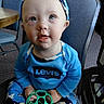 toddler, child, blue_eyes, headband, toy, green_toy, levis, blue_clothing, camouflage, pants, indoor, chair, table, carpet, person, baby, sitting, curious, face, cute