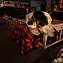 dog, pet, indoor, couch, sweater, red_and_black, checkered, living_room, holiday_decor, blanket, furniture, cozy, warm_lighting, animal, cute, portrait, small_dog, domestic, side_view, decor