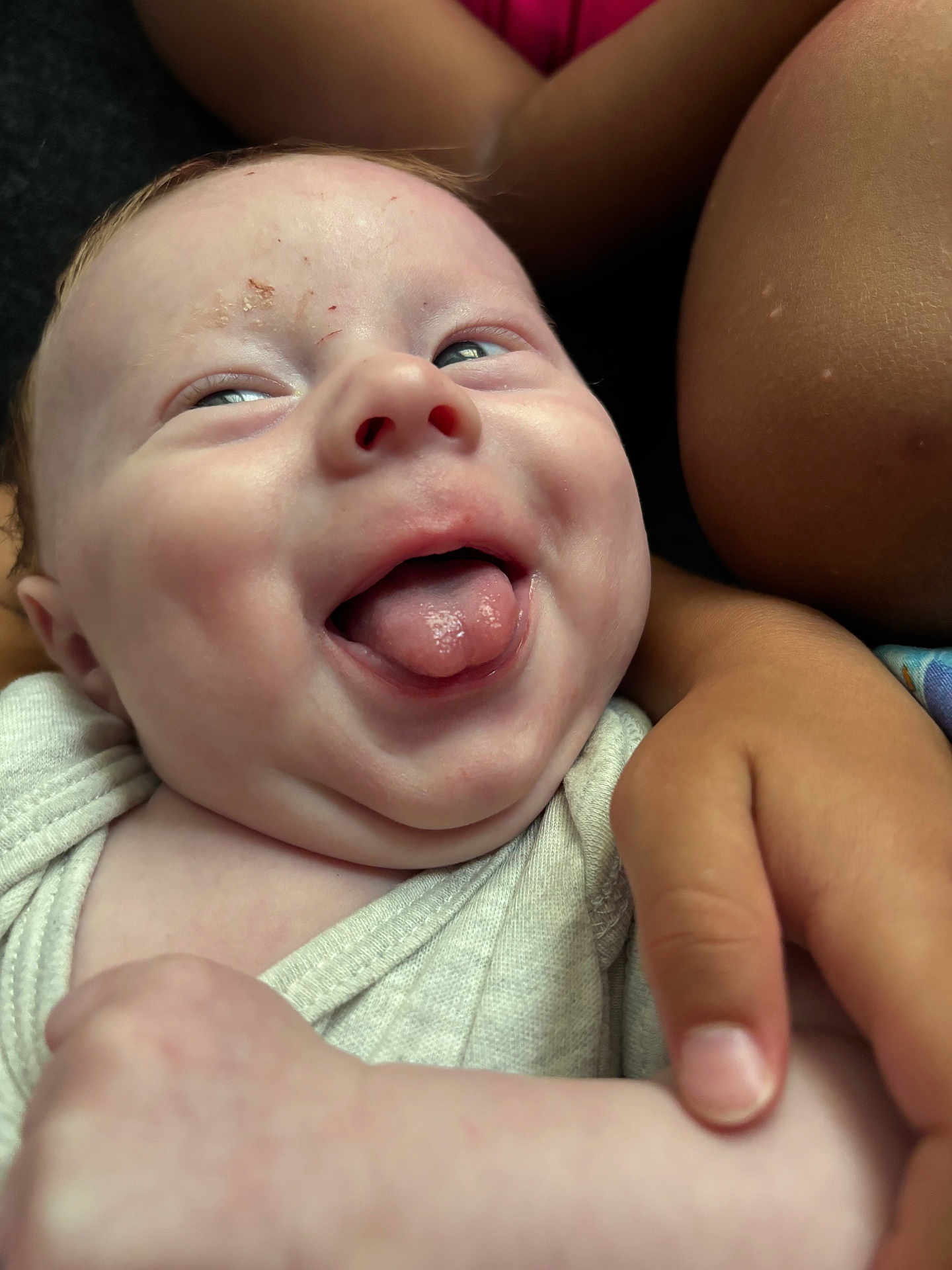 Shawn is registered to the contest to win money with this photo: baby, child, tongue, smiling, face, arm, hand, skin, infant, closeup, expression, cute, person, holding, joy, happy, sibling, affection, clothing, portrait