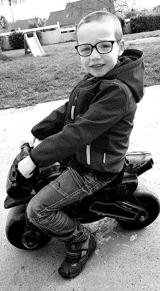 Jeydon a rejoint le concours — aidez-le/la à gagner de superbes lots ! black, black_and_white, child, cool, eyewear, footwear, glasses, monochrome, monochrome_photography, person, personal_protective_equipment, photograph, photography, shoe, sitting, smile, snapshot, sunglasses, toddler, vehicle