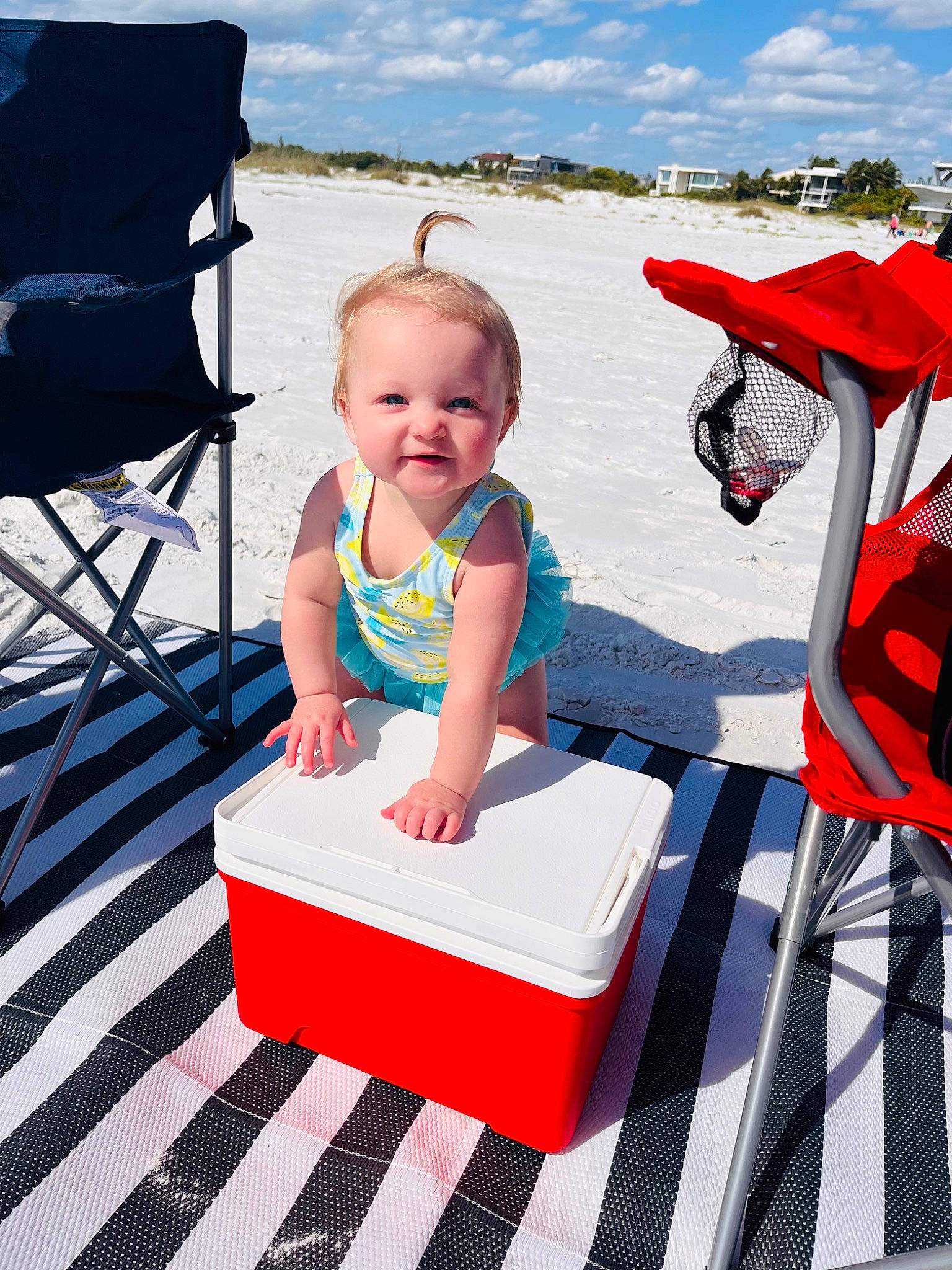 Marcy is registered to the contest to win money with this photo: baby, baby_toddler_clothing, blue, chair, child, cloud, dress, fun, happy, leisure, outdoor_furniture, person, product, recreation, red, sky, smile, summer, toddler, travel