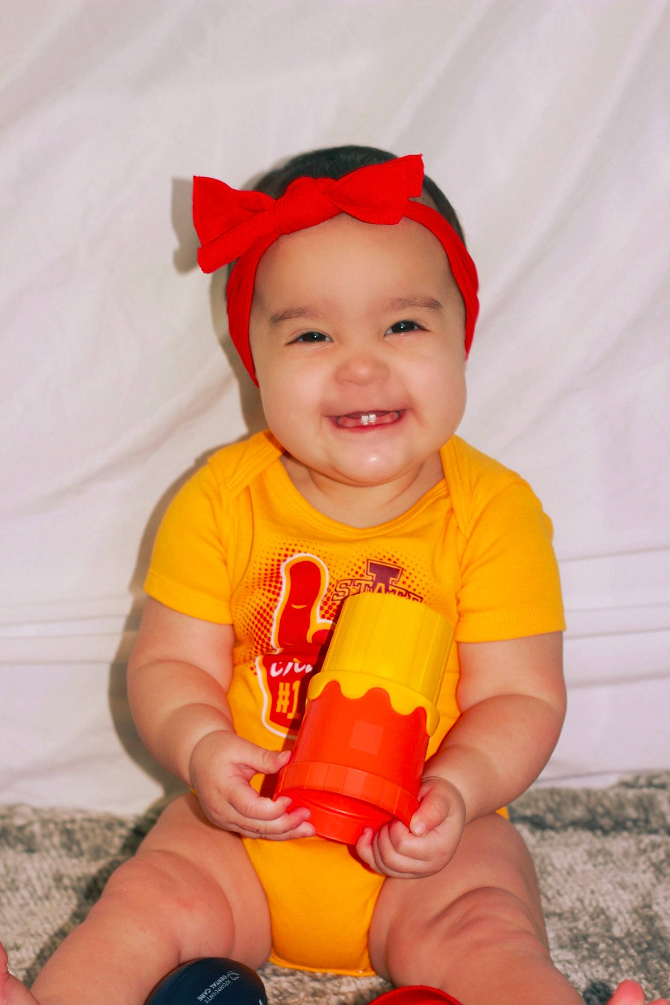 Evalina is registered to the contest to win money with this photo: baby, baby_toddler_clothing, eye, facial_expression, footwear, happy, head, headwear, human_body, joy, mouth, muscle, orange, organ, person, pink, product, shoe, shorts, skin