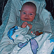 Eva a rejoint le concours — aidez-le/la à gagner de superbes lots ! baby, blanket, pacifier, smile, cozy, infant, clothing, face, happy, wrapped, soft, cute, lying_down, indoors, child, warm, comfort, portrait, newborn, resting