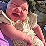 baby, child, laughing, headband, knitwear, cream_color, arm, person, indoor, living_room, couch, rug, furniture, happy, smile, cute, infant, closeup, cozy, portrait