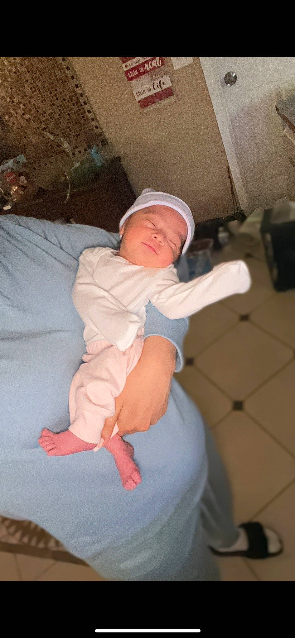 Elsa is registered to the contest to win money with this photo: baby, baby_toddler_clothing, baseball_cap, cap, child, comfort, elbow, finger, hat, human_leg, knee, lap, linens, person, sitting, sleeve, t_shirt, thigh, thumb, toddler