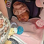 baby, sleeping, car_seat, pink, blanket, head_wrap, pacifier, plush_toy, soft_toys, infant, cozy, cute, child, face, smile, resting, indoors, comfort, newborn, peaceful