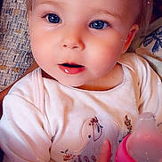 Arianna joined the competition — help win amazing prizes! baby, baby_bottle, blanket, blue_eyes, bottle, child, close_up, clothing, couch, face, indoors, infant, onesie, pink, portrait, sitting, smiling, spring, text_overlay, wide_eyed