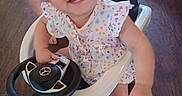 Olivia joined the competition — help win amazing prizes! alloywheel, baby, car, carwheel, clothing, face, happy, head, indoors, machine, person, photography, portrait, spoke, steeringwheel, t_shirt, tire, transportation, vehicle, wheel