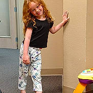 Autumn joined the competition — help win amazing prizes! child, girl, red_hair, curly_hair, black_shirt, floral_pants, sneakers, indoor, carpet, wall, door, toy, playful, smiling, posing, young, person, casual_clothing, room, happy