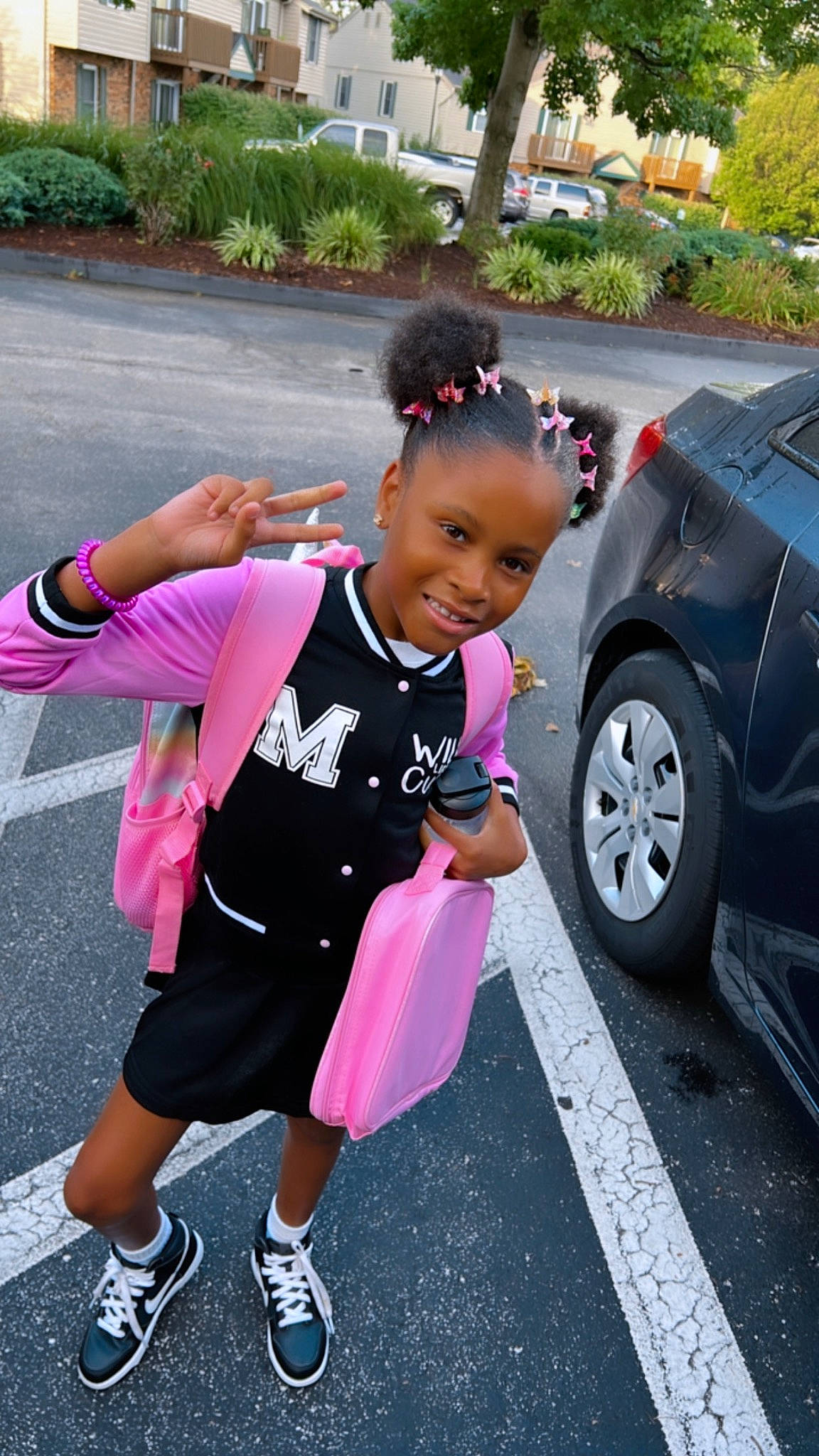 Azaria is registered to the contest to win money with this photo: asphalt, automotive_design, automotive_exterior, automotive_tire, car, happy, joy, leisure, magenta, motor_vehicle, parking, person, pink, plant, recreation, road, shorts, sidewalk, tire, toddler