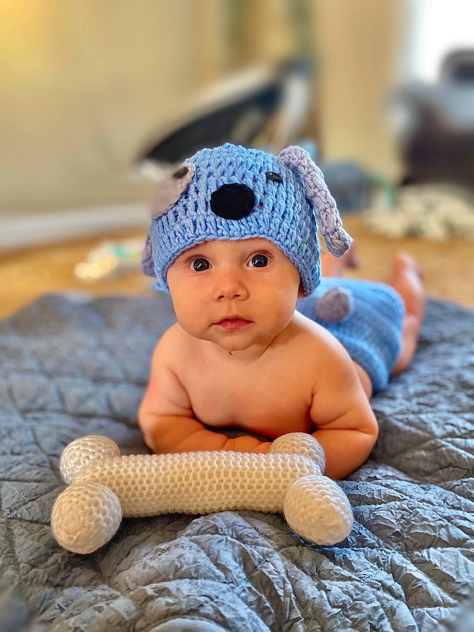 Koah is registered to the contest to win money with this photo: baby, baby_products, baby_toddler_clothing, beanie, cap, doll, fashion_accessory, fawn, flooring, foot, fur, headgear, headwear, knit_cap, linens, person, sitting, thumb, toy, wood