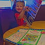 child, girl, pigtails, menu, restaurant, table, booth, placemat, activity, smile, indoor, lighting, wood, happy, clothing, food, play, seat, person, dining