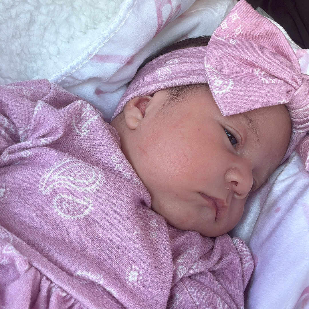 Lara Moreno is registered to the contest to win money with this photo: baby, blanket, bow, cheek, closeup, clothing, cute, ear, eye, face, headband, infant, newborn, pattern, pink_clothing, portrait, resting, sleepy, soft_fabric, wrapped