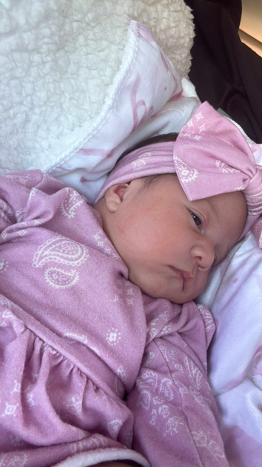 Lara Moreno is registered to the contest to win money with this photo: baby, newborn, infant, headband, bow, pink_clothing, blanket, soft_fabric, cheek, face, ear, eye, portrait, closeup, sleepy, clothing, pattern, wrapped, resting, cute
