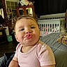 Kaylie joined the competition — help win amazing prizes! toddler, child, cute, funny_face, indoor, crib, cabinet, curly_hair, pink_shirt, baby, furniture, home, portrait, expression, person, smile, room, curtains, toy, baby_clothes