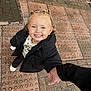 black_jacket, blonde_hair, casual_clothing, child, cute, daylight, footwear, hand, happy, holding_hands, joy, outdoor, pavement, person, pigtails, portrait, smile, urban, walking, young