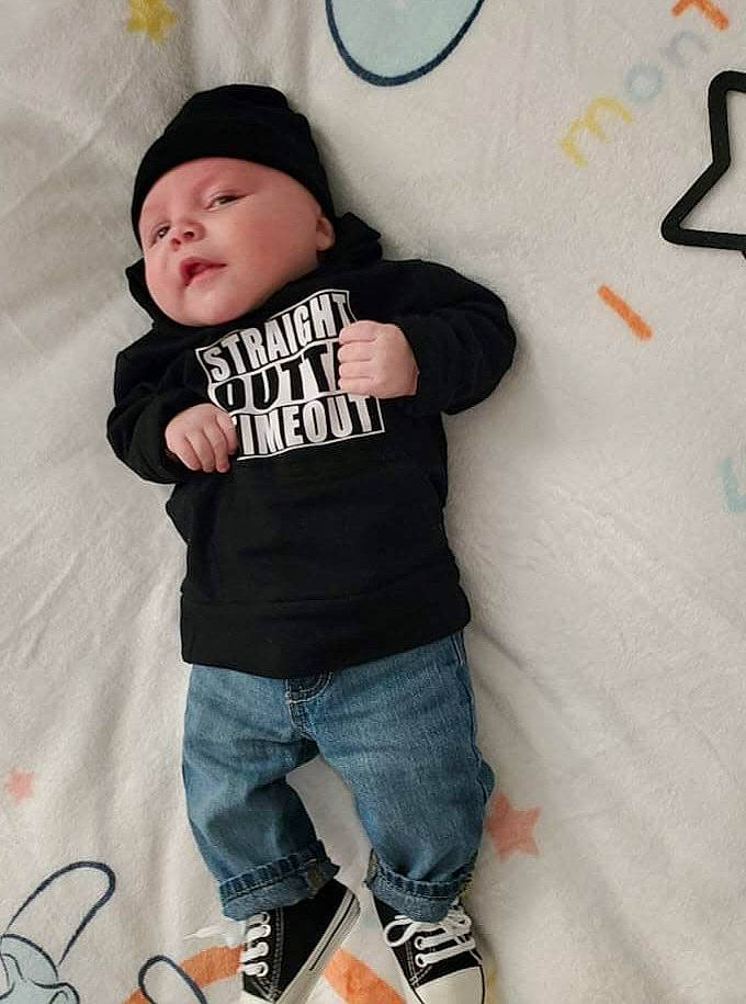 Flynn is registered to the contest to win money with this photo: baby, baby_toddler_clothing, cap, child, cool, denim, face, font, headwear, jeans, knee, orange, pattern, person, pink, sleeve, t_shirt, textile, thigh, toddler