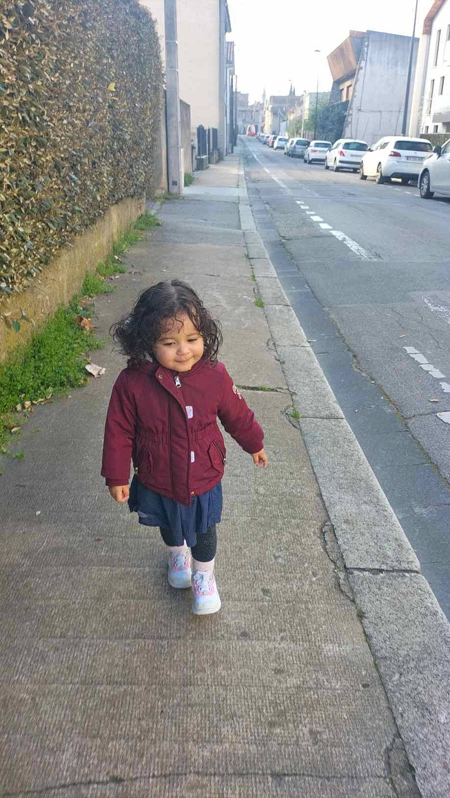 Asma participe au concours pour gagner de l'argent avec cette photo : asphalt, baby_toddler_clothing, car, child, city, grass, lane, pedestrian, person, plant, road, road_surface, shadow, sidewalk, street, tar, tire, toddler, walking, wheel