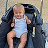 Kohen is registered to the contest to win money with this photo: baby, child, stroller, romper, outdoor, smile, happy, infant, seat, foot, skin, face, person, sunlight, summer, casual, one_person, cute, young, playful