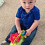 toddler, child, toy, carpet, blue_shirt, jeans, socks, indoor, play, cute, young_child, sitting, looking_up, colorful, plastic_toy, small_person, casual_clothing, infant, baby, floor