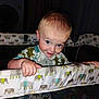 Axel is registered to the contest to win money with this photo: toddler, child, playpen, elephant_pattern, blue_eyes, smile, curious, indoor, pajamas, baby, hand, face, person, young_child, furniture, nighttime, cute, infant, home, portrait