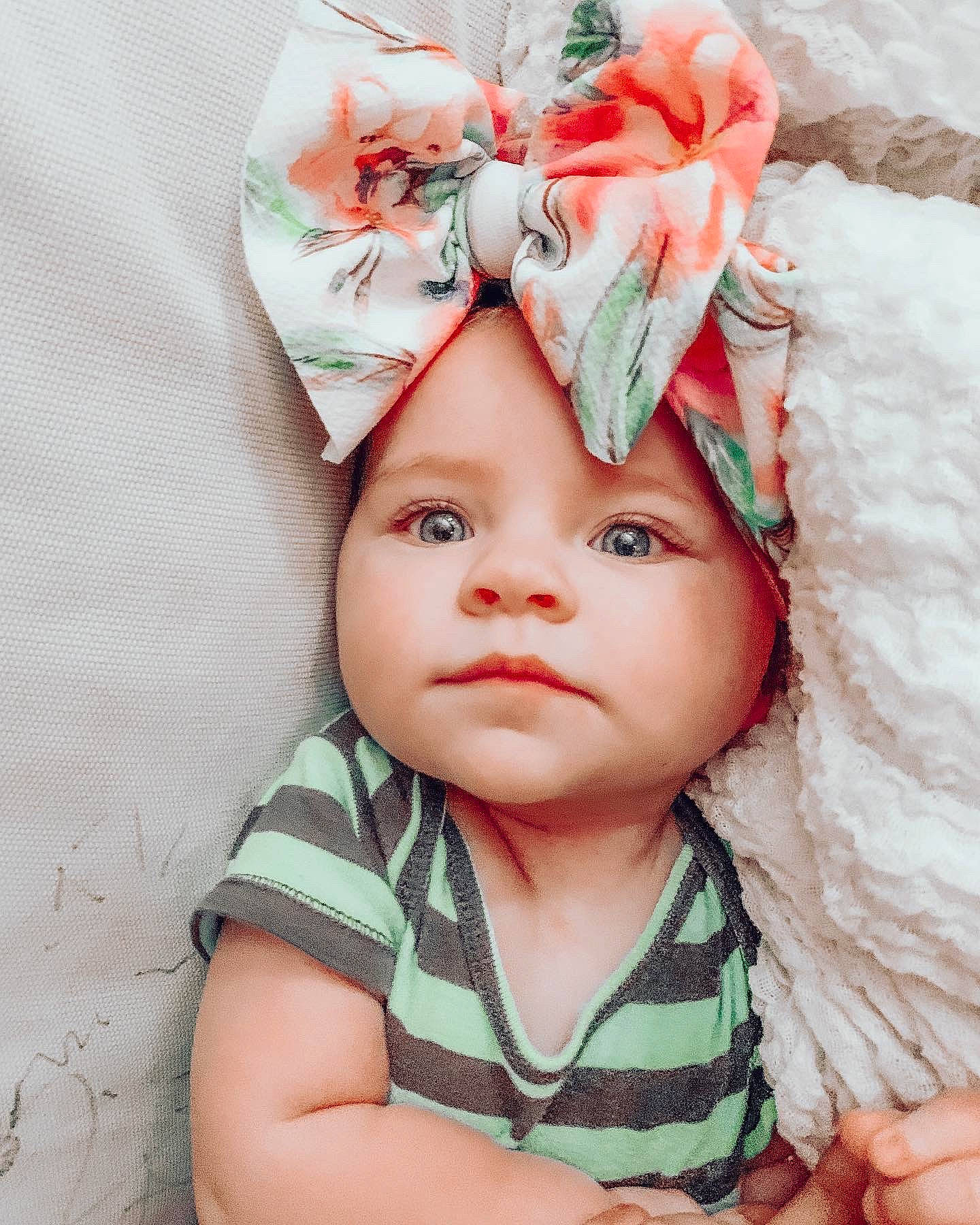 Hallie joined the competition — help win amazing prizes! baby, baby_products, baby_sleeping, cheek, child, child_model, clothing, face, fashion_accessory, hair_accessory, hat, head, headgear, headwear, lip, person, photography, pink, plant, product