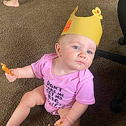 Davina joined the competition — help win amazing prizes! baby, barefoot, burger_king, carpet, child, crown, crumbs, curious, cute, expression, floor, food, headwear, indoor, legs, mischievous, onesie, person, pink_clothing, sitting