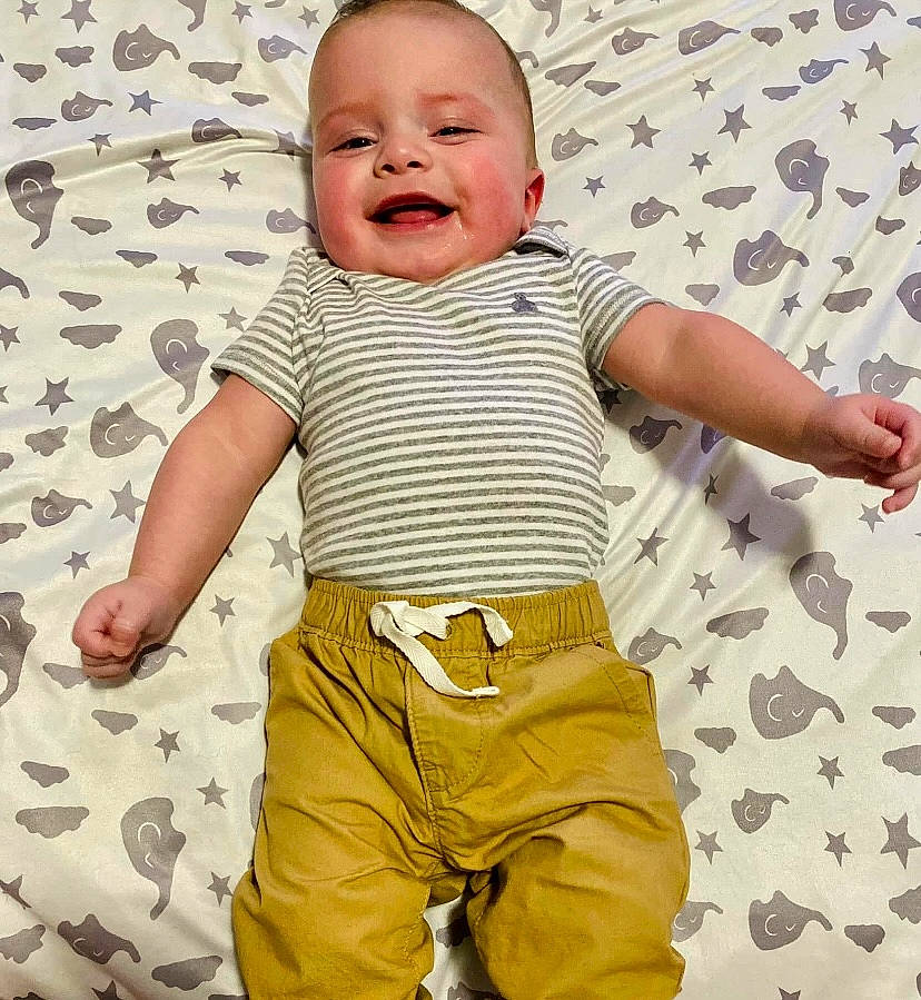 Walter is registered to the contest to win money with this photo: baby, baby_toddler_clothing, cargo_pants, child, collar, cool, gesture, happy, joy, khaki_pants, pattern, people_in_nature, person, photograph, product, skin, sleeve, smile, t_shirt, textile
