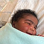 Maame Yaa is registered to the contest to win money with this photo: baby, blanket, smiling, sleeping, curly_hair, towel, face, infant, newborn, soft_texture, blue, closeup, cute, resting, wrapped, person, child, indoors, peaceful, skin