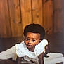 Maame Yaa joined the competition — help win amazing prizes! baby, crawling, infant, wooden_floor, white_outfit, curious, soft_rug, indoor, portrait, child, cute, smiling, dark_skin, short_hair, young, hands, knees, looking_at_camera, warm_lighting, cozy