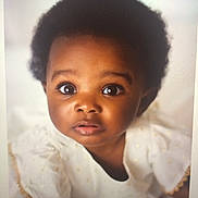 Maame Yaa is registered to the contest to win money with this photo: baby, infant, child, afro_hair, white_clothing, portrait, face, eyes, curious, cute, innocence, soft_background, expression, person, closeup, young_child, adorable, skin, head, fashion