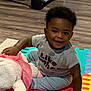 Kwabena joined the competition — help win amazing prizes! toddler, child, plush_toy, indoor, floor, foam_mat, colorful, smiling, happy, clothing, pants, shirt, baby, person, play, toy, cute, young_child, carpet, home