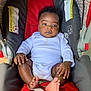 Kwabena is registered to the contest to win money with this photo: baby, infant, car_seat, white_onesie, red, gray, footwear_free, cute, child, small_hands, small_feet, indoors, seatbelt, snugride, drool, curly_hair, portrait, person, comfort, relaxed