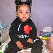 Maryam participe au concours pour gagner de l'argent avec cette photo : toddler, child, black_clothing, sitting, indoors, bed, double_buns, baby, pink_socks, facial_expression, holding_object, lotion, tissues, scissors, table, hair_style, person, cute, casual, portrait