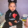 toddler, child, black_clothing, sitting, indoors, bed, double_buns, baby, pink_socks, facial_expression, holding_object, lotion, tissues, scissors, table, hair_style, person, cute, casual, portrait