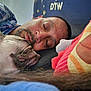 man, dog, sleeping, close_up, face, cozy, indoor, pillow, rest, pet, companion, relaxation, casual_clothing, beard, head, napping, comfort, animal, friendship, bond