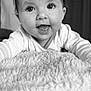baby, infant, face, eyes, smile, tongue, blanket, soft_texture, close_up, black_and_white, cute, child, portrait, happy, indoors, young, expression, clothing, head, person